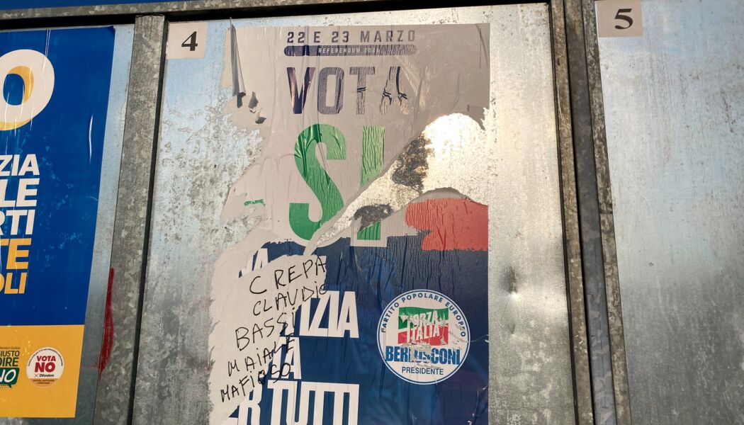 Il manifesto di Forza Italia strappato con la scritta "Crepa Claudio Bassi maiale mafioso"